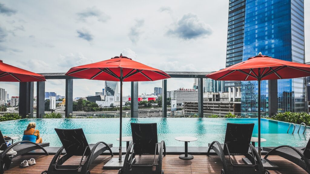 Guests relaxing by the infinity pool at Amari Kuala Lumpur with cityscape backdrop