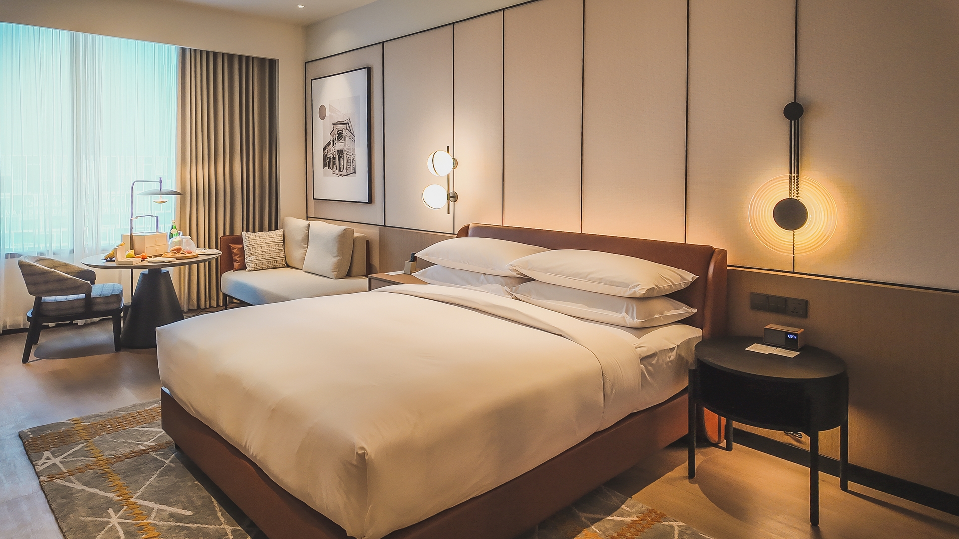 带有北欧风装饰、温暖木质点缀和沙色宁静色调的新山喜来登酒店客房。