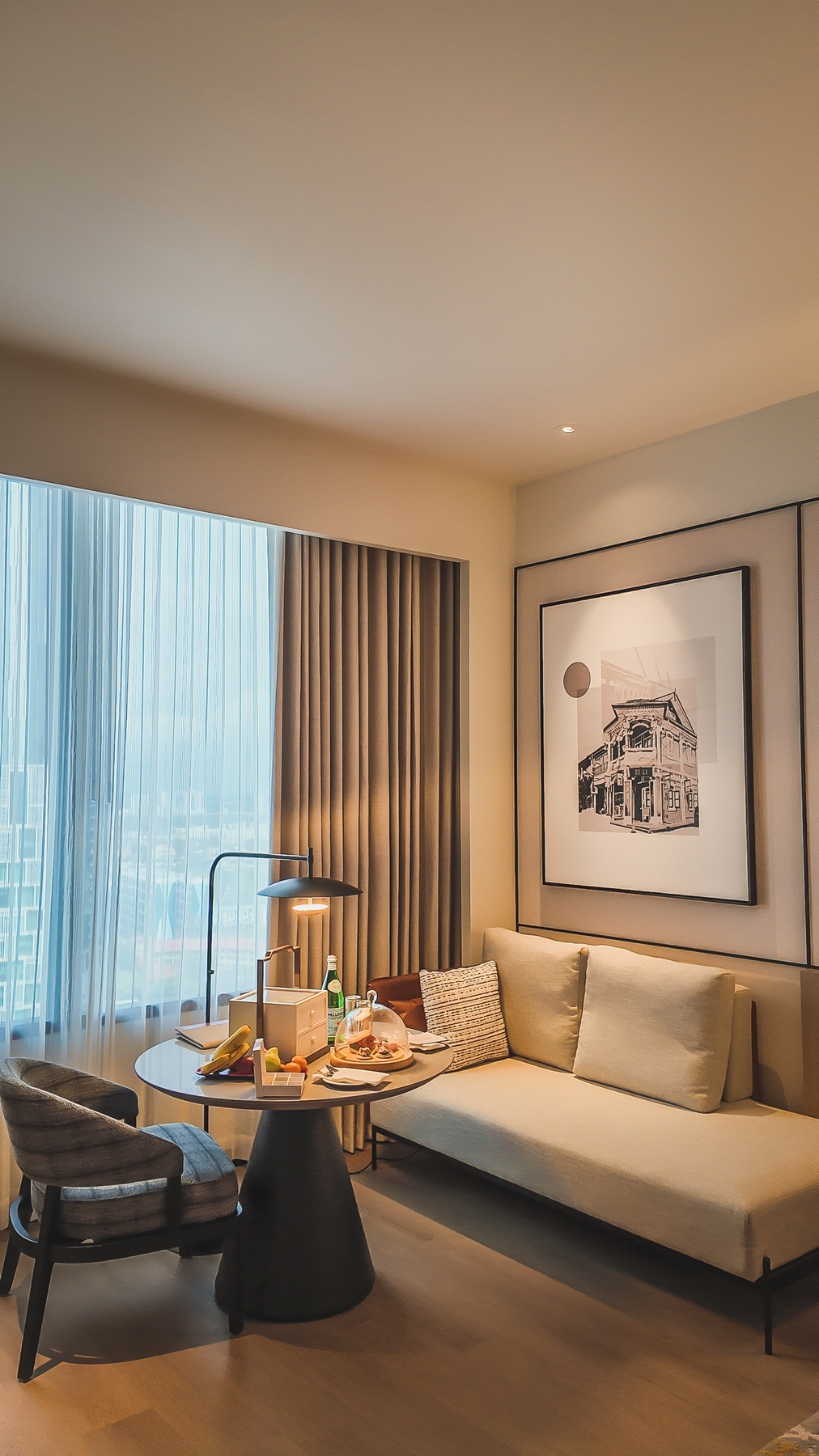 国王房展示圆形餐桌、贵妃椅和开放式布局，提供灵活生活空间，新山喜来登酒店。