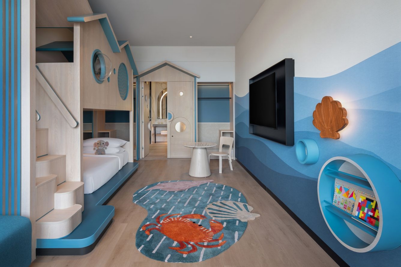 家庭套房包含主卧室、儿童双层床及海洋灵感的蓝绿色装饰，新山喜来登酒店。